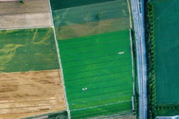 Aerial view of diverse agricultural fields and a highway.