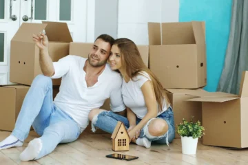Couple sitting on floor surrounded by moving boxes