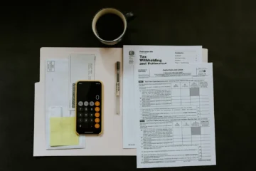Financial documents and a calculator, representing income and savings requirements for Mexican residency